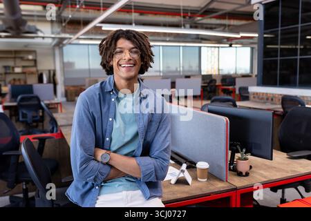 In office, African American man standing confidently, feeling relaxed and smiling Stock Photo