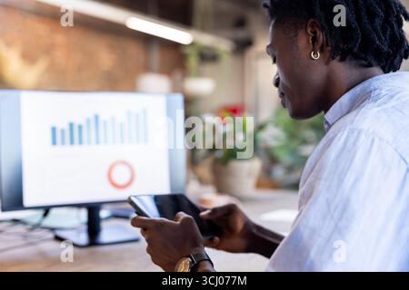 Business professional analyzing data on tablet and computer in modern office Stock Photo