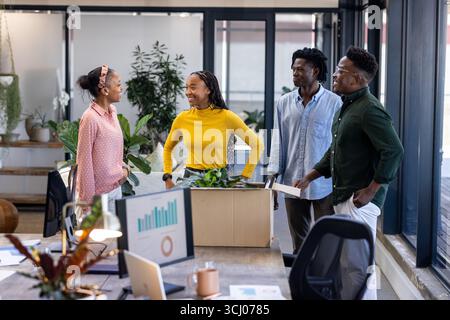 Team discussing new project ideas in modern office, surrounded by plants Stock Photo