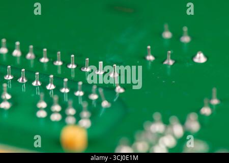 circuit board with contacts, a green printed circuit board with an electronic circuit with soldered elements Stock Photo