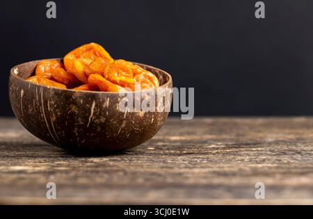 orange dried apricots made from ripe apricots in a coconut plate, dried apricots in a bowl made from natural materials Stock Photo