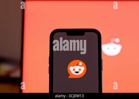 Opening the Reddit social media app on smartphone screen Stock Photo