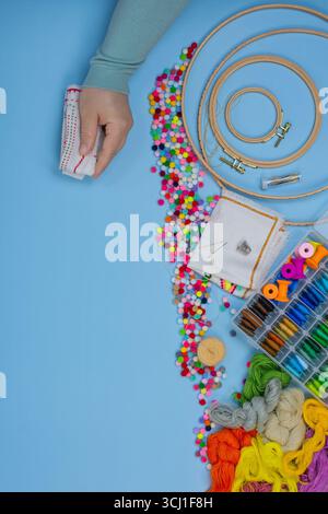 Girl preparing threads for embroidery. Female hands embroider on blank canvas. Woman in her embroidery studio. Stock Photo