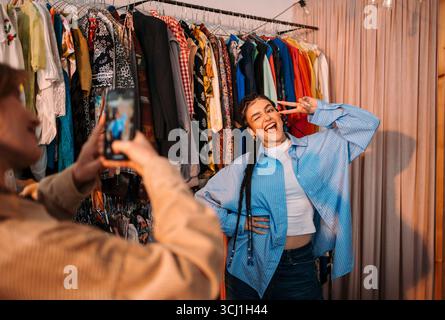 A trendy young woman confidently poses for a photo in a stylish clothing store Stock Photo