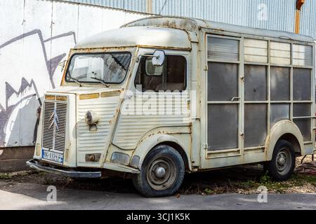 A vintage and heavily weathered Citroën H Van, capturing its iconic corrugated body and the rustic beauty of age and neglect. Concept Grunge and Age Stock Photo