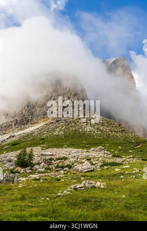Famous Drei Zinnen mountains stand peacefully under soft blue sky in Italian Alps. A calm alpine view, perfect for nature-focused tourism, lifestyle v Stock Photo