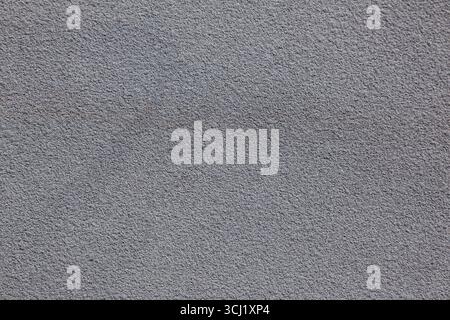 Texture of gray asphalt and gray fine-grained wall surface, creating a neutral industrial background with subtle rough details. Stock Photo