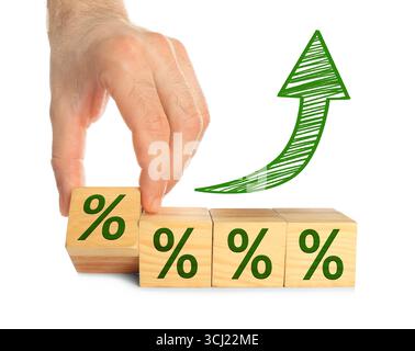 Man holding wooden cube with percent sign against white background, closeup Stock Photo