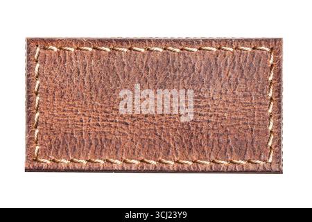 Brown stitched leather patch closeup. Rustic textured material label. Vintage style tag background. Handmade stitches detail. Retro leather craft. Stock Photo