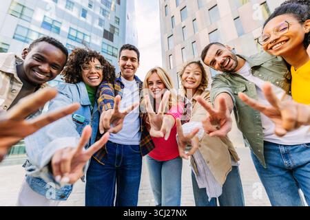 Happy students gesturing peace sign in the city Stock Photo
