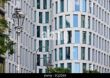 Facade of tall modern office building with white curves and glass windows in Berlin, daylight, vertical composition, perfect for real estate, architec Stock Photo