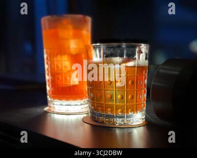 Close-up of 2 cocktails singapore sling & old fashioned in patterned glasses dimly lit table atmosphere singapore Atico Lounge & bar ION orchard Stock Photo