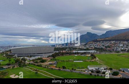 An aerial shot of the Cape Town Stadium and its surrounding green fields. The peculiar cloud formation in this photo is a lenticular cloud. Stock Photo