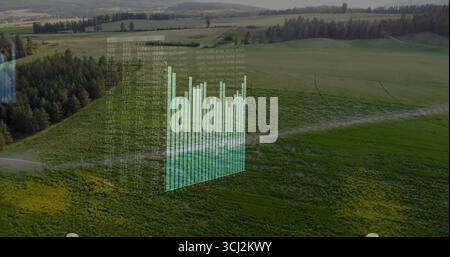 Displaying holographic overlay with 3D bar chart and floating numeric matrix above rural farmland. Agriculture, rural, visualization, technology, data Stock Photo