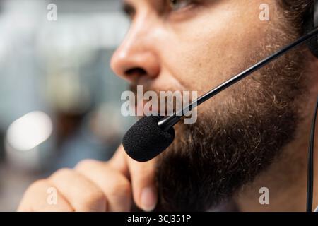 Close up of stockbroker talking with clients using audio headset mic, executing buy and sell orders. Financial expert speaking in headphones microphone, advising on investment opportunities Stock Photo