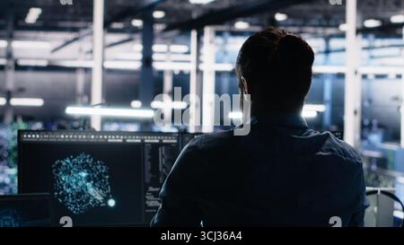 Server room technician stretching sore back while using AI at desk. Fatigued IT expert in data center relaxing strained muscles, feeling backache while using artificial intelligence, camera A Stock Photo