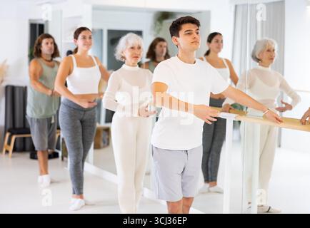 Diligent young man doing choreography at ballet barre Stock Photo