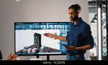 Property developer leads the planning session with 3D models for details and zoning regulations, focusing on site development and infrastructure growth for housing and urban development. Stock Photo