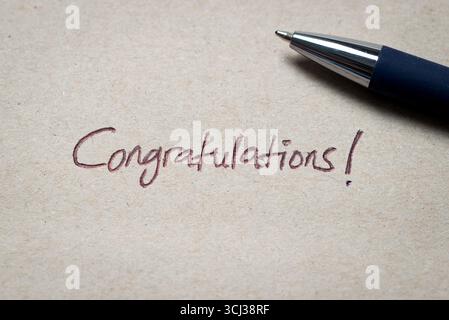 A close-up of a handwritten Congratulations written in ink on paper, symbolizing celebration, achievement, and positive acknowledgment. Stock Photo