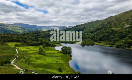 Cloudy day over the tranquil Rydal Water and wooded hillsides in the Lake District Stock Photo