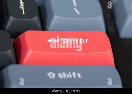 close up from a Red enter keyboard key with focus on the return key Stock Photo