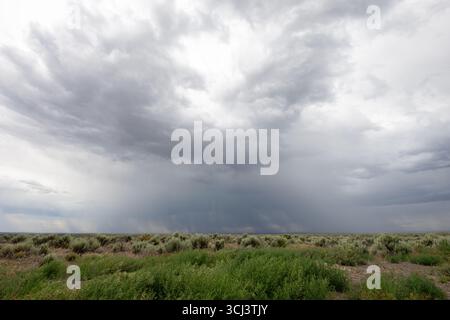 A cloudy sky with a large storm cloud in the middle Stock Photo