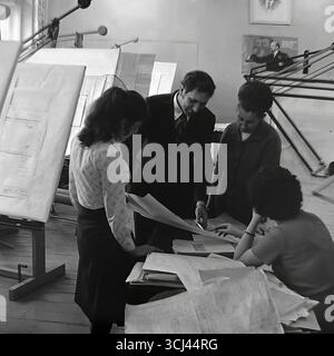 Engineers in a design bureau at a plant in Sloviansk collectively discussing blueprints, January 1978. The archival photograph shows the working atmosphere among the Soviet scientific and technical intelligentsia during the Era of Stagnation. This scene of intellectual, creative labor is a symbol of the peaceful scientific potential of Donbas before the wa Stock Photo