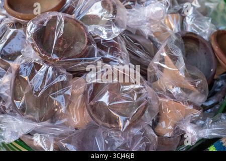clay earthenware bowls on sale in plastic bags  in the souk market in the medina in Marrakesh, Morocco Stock Photo