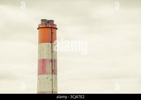 large white red stripe industry chimney, hot gas pipe releases against cloudy sky background Stock Photo
