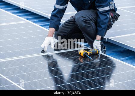 Professional Engineer Service Solar Panel. Worker Maintenance Cleaning Replacing Solar Panel. Solar photovoltaic panel system in Industry roof. Saving Stock Photo