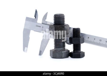 Close-up of a caliper measuring a bolt and nut, demonstrating precision in engineering and mechanics. Includes a focus on measurement accuracy and har Stock Photo