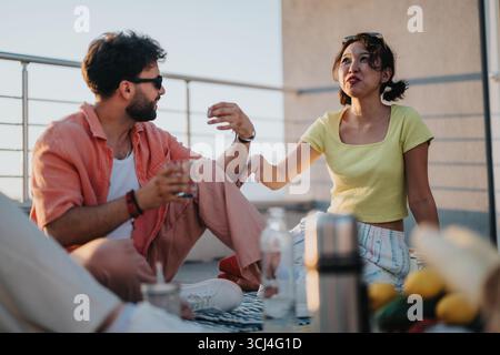 Friends enjoying a casual rooftop gathering during a pleasant sunny afternoon Stock Photo