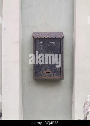 Old metal mailbox hanging on the wall of the house, copy space Stock Photo