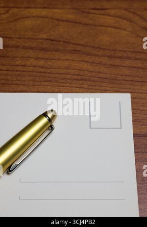 golden pen and postacrd on table Stock Photo