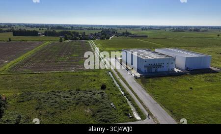 Modern data center facility situated in a rural landscape of Lombardy Italy surrounded by agricultural fields and infrastructure providing secure clou Stock Photo