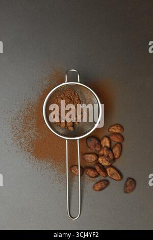 Kitchen sieve with cocoa powder, cocoa and cocoa beans Stock Photo
