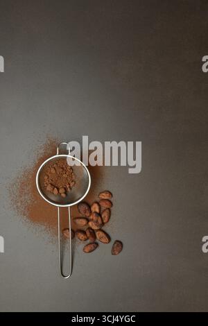 Kitchen sieve with cocoa powder, cocoa and cocoa beans Stock Photo