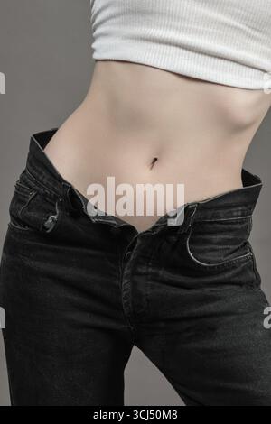 Young woman show her beautiful slim female body in a white tank top close up view Stock Photo