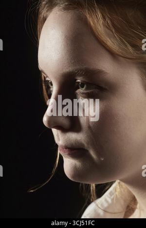sad woman crying, looking aside on black background, closeup portrait ...