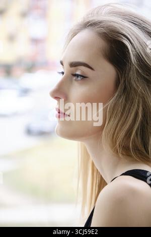 Serious sad beautiful blond woman looking away side profile view Stock Photo