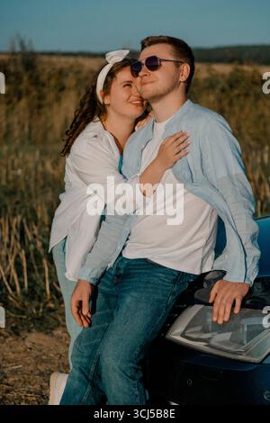 Couple enjoying romantic moment near car Stock Photo