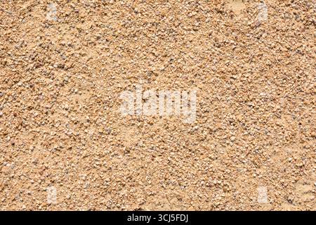 Background detail of a path with dirt and small stones on a sunny day. Top view. Stock Photo