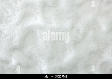 Background with macro of white soft textured soap foam with many small bubbles. Top view. Stock Photo