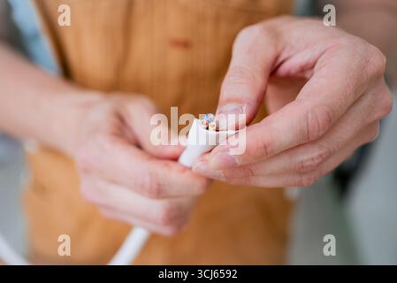 Close-up of electrician's hands carefully connecting wires of electric stove cable during home appliance installation or repair, demonstrating precision and expertise in electrical work Stock Photo