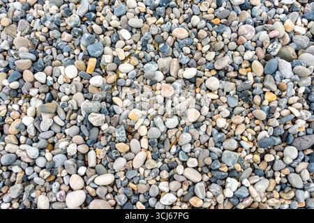 Pebbles On A Beach Hornsund Svalbard Norway | HORNSUND, Svalbard — A dense carpet of smooth, wave-rounded pebbles covers a beach at Hornsund, on the southern coast of Spitsbergen. The stones' grey, beige, and blue tones come from a mix of local metamorphic and sedimentary rock, worn round by centuries of wave and glacial action along this Arctic shoreline. Stock Photo