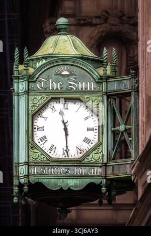 The New York Sun Clock - This close-up photograph captures the ornate, bronze, weathered green clock with "The Sun" inscribed at the top. Stock Photo