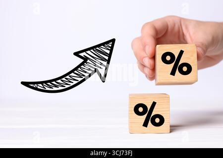 Man holding wooden cube with percent sign against white background, closeup Stock Photo