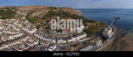 Aerial panorama of Llandudno Pier, the Great Orme, and the seaside town under clear summer skies. Stock Photo