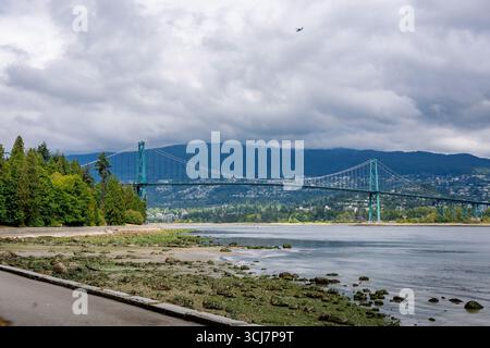 A view of the Lions Gate Bridge looking north from Stanley Park in Vancouver, Canada on a cloudy, overcast day Stock Photo