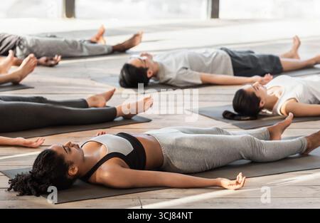 Savasana Pose. Diverse Yoga Class Members Meditating On Floor, Lying On Mats Stock Photo